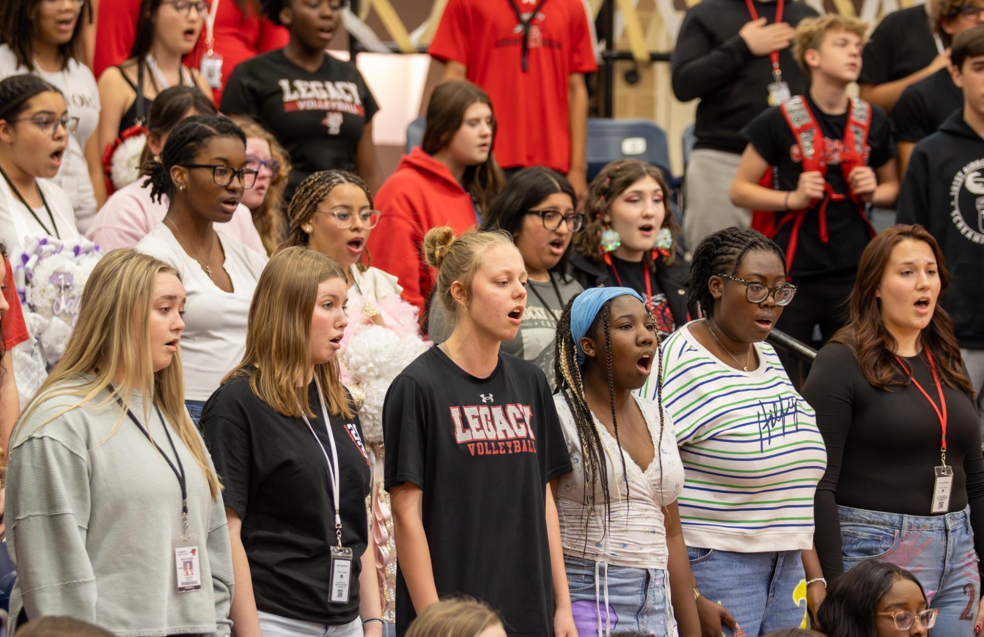 Standing toward the flag, choir sings the national anthem at the homecoming pep rally Oct. 24. 