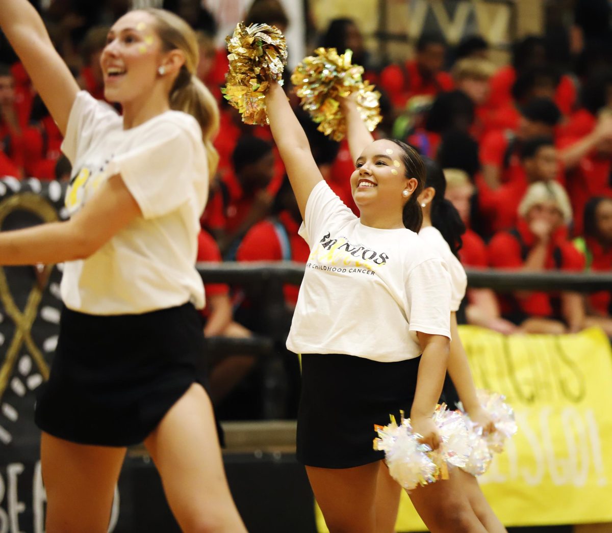 During the gold out pep rally, Emily Aredande waves her poms in the air. 