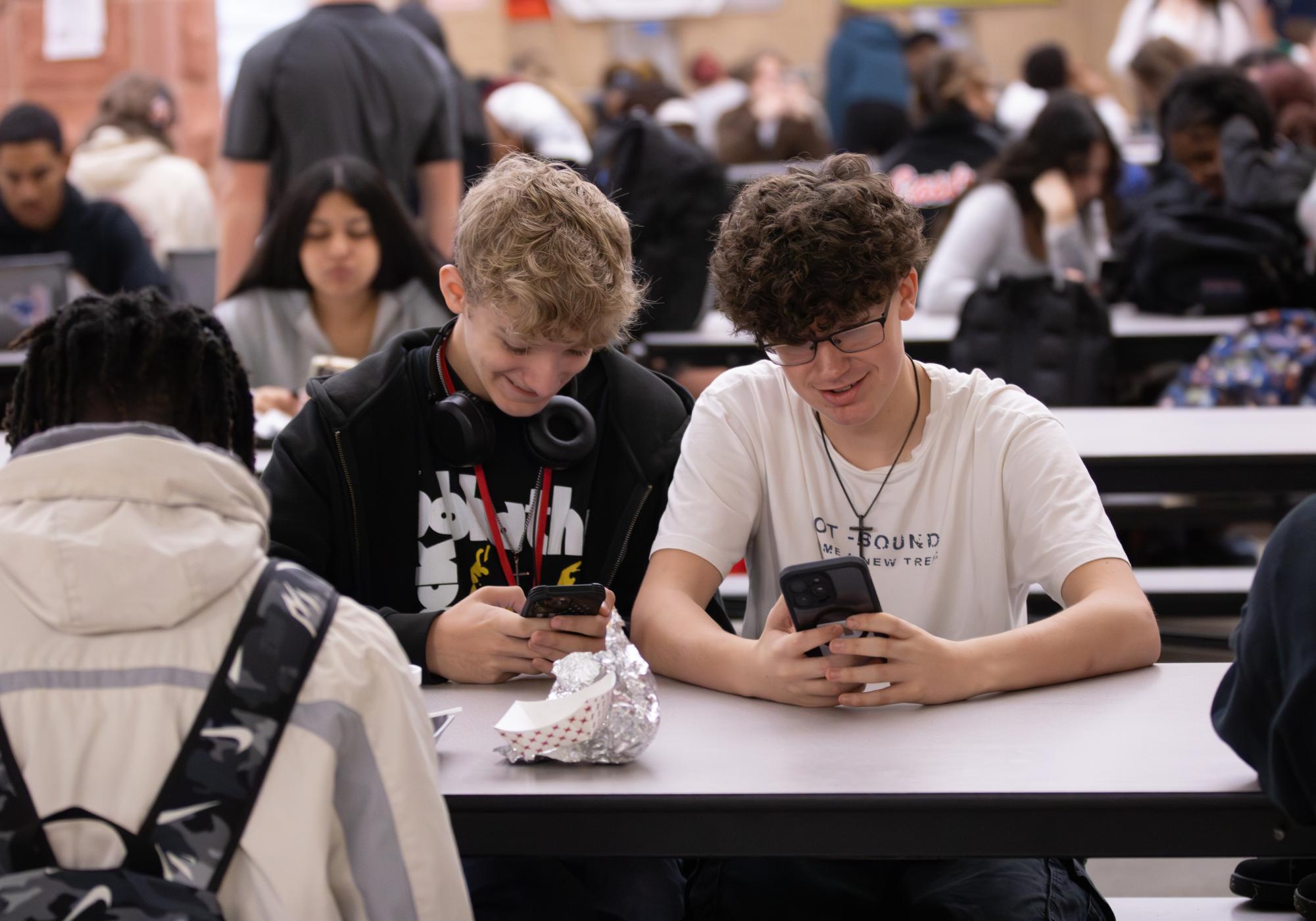 Students use their phone during lunch in the cafeteria. Although technology remains useful for people’s everyday life, it hinders the ability to communicate effectively with each other, according to Tech Review Advisor. 