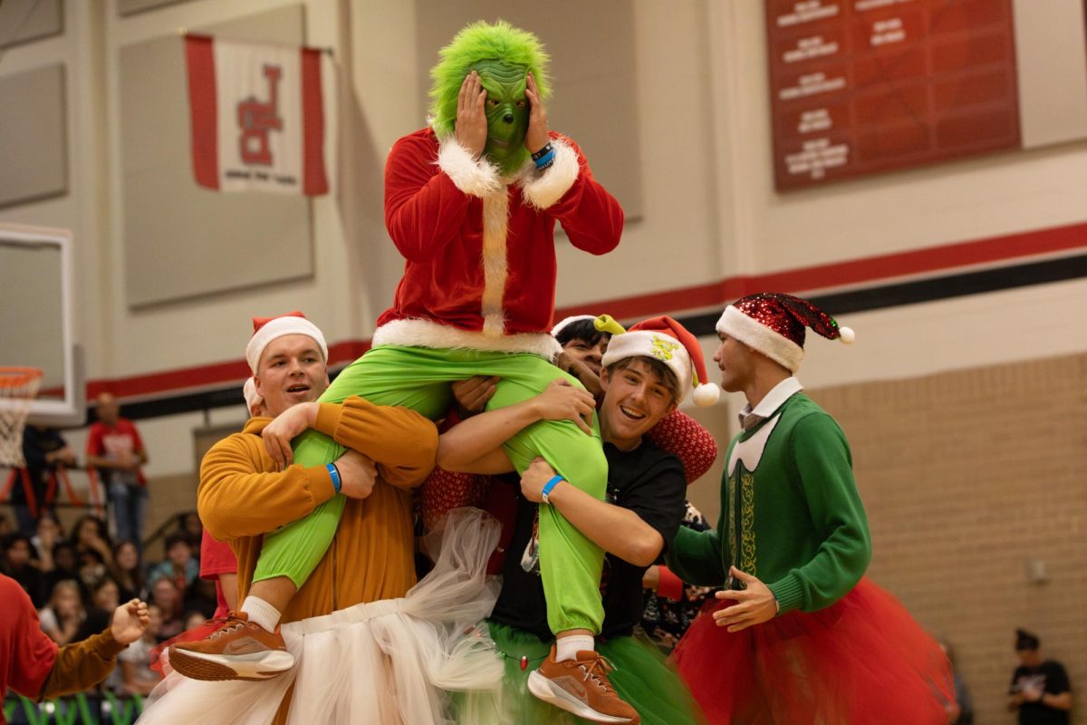 Mr. Grinch:
Students lift Carson Cox, 12, during the Toys for Tots pep rally halftime show Nov. 21