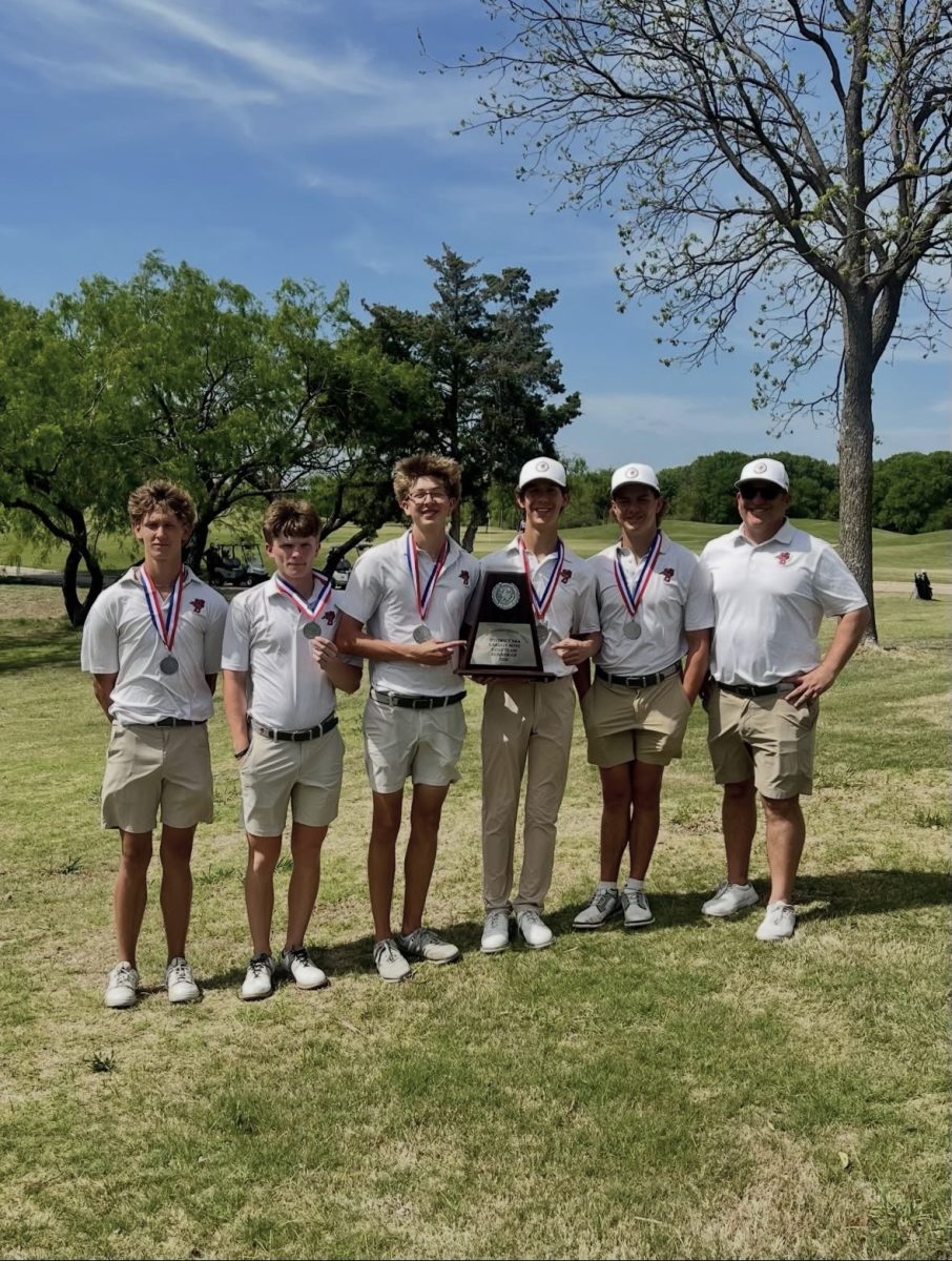 The varsity boys team poses with their district plaque on March 31. They placed second in district, securing them a spot at regionals.