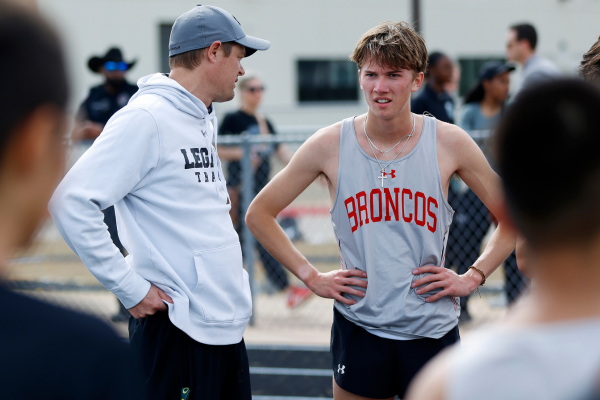 Senior Lincoln Wright talks to Coach Lindsey before running in the 800m at the district meet.