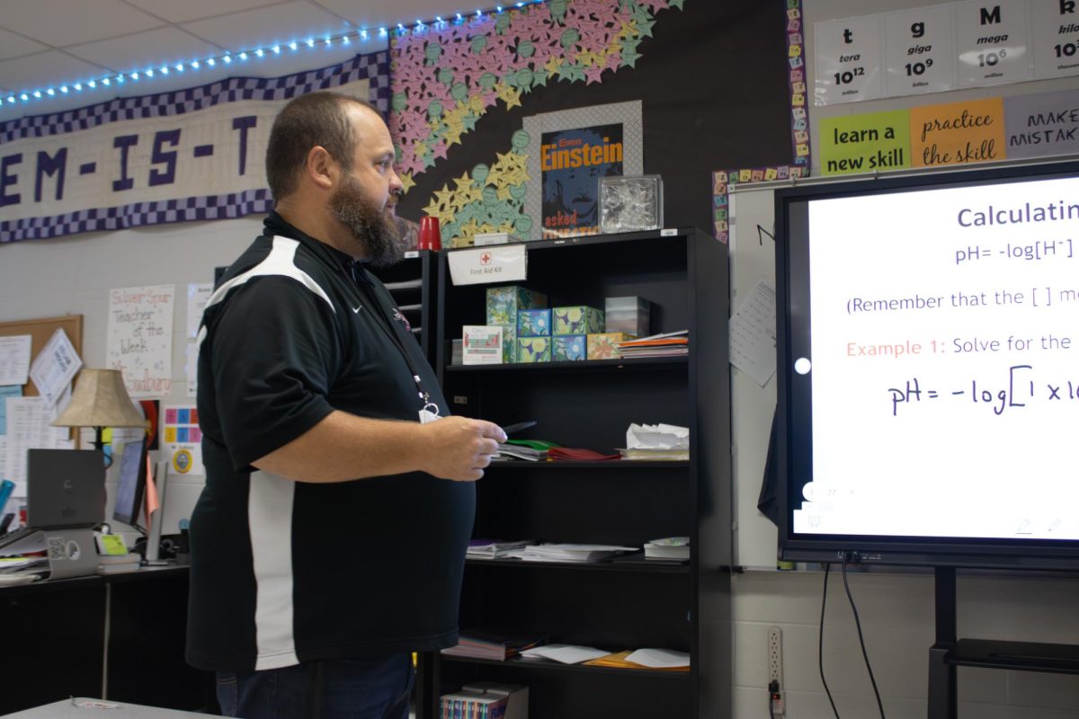 During chemistry class on April 29, science teacher John Sudbury directs a slideshow about logarithms for his students.
